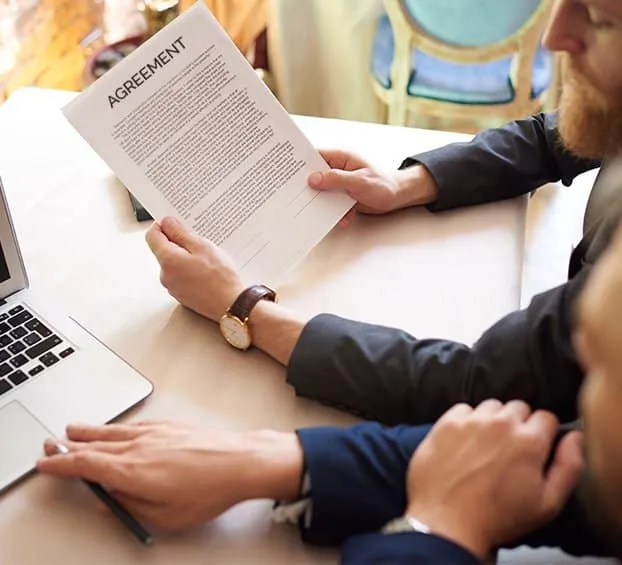 Legal and financial experts drafting a preliminary agreement for an M&A deal.